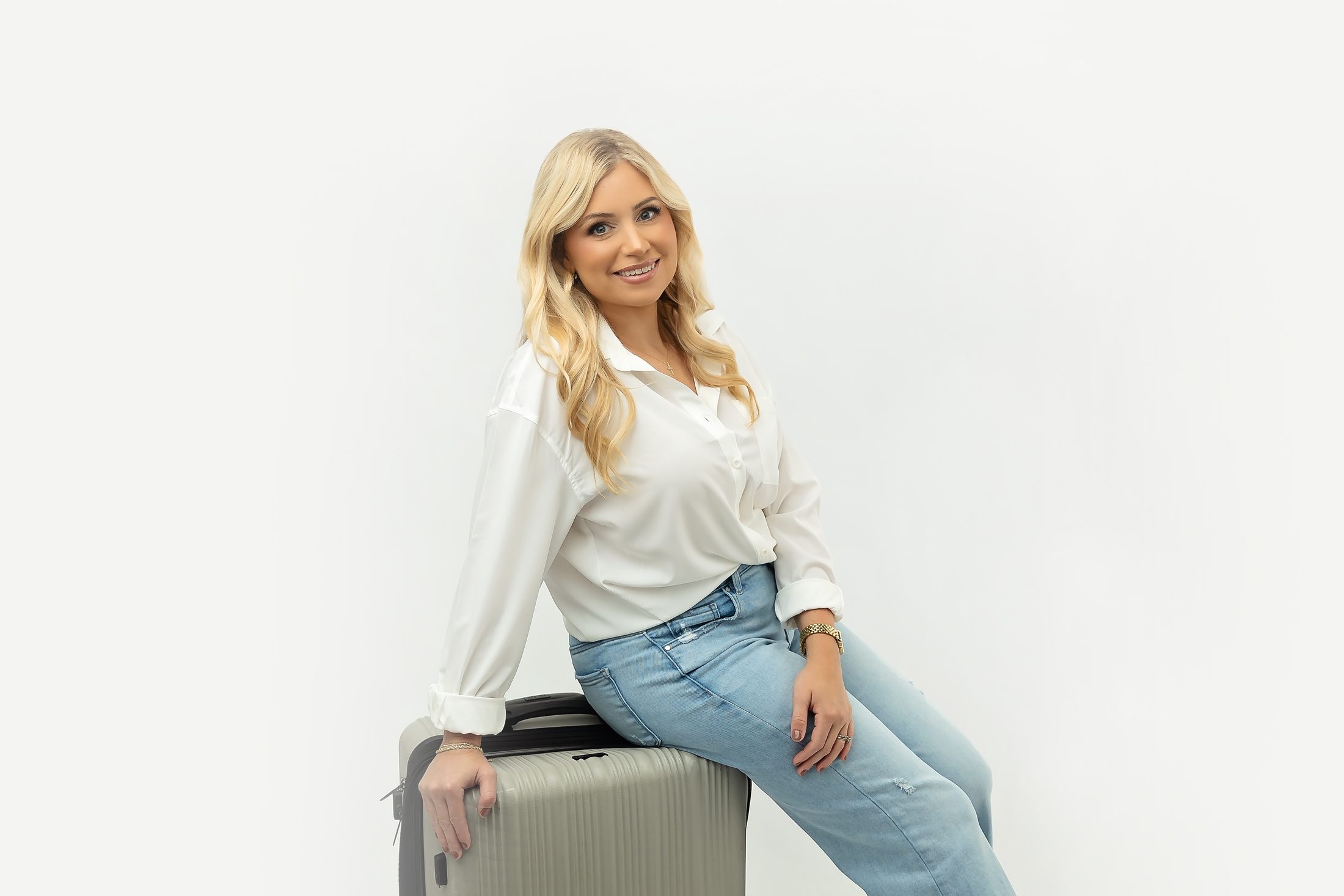 Lindsay Delahoussaye seated on a suitcase