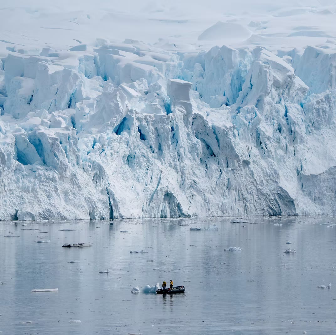 Expedition zodiac beneath a glacier in Borgen Bay, Antarctica